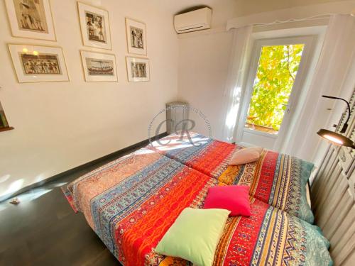 1 dormitorio con 1 cama con una manta colorida en APPARTEMENT DUPLEX - 100M DE LA PLAGE DE ST CLAIR, en Le Lavandou