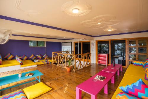 una sala de estar con sofás y mesas coloridos. en goSTOPS Kasar Devi, en Almora