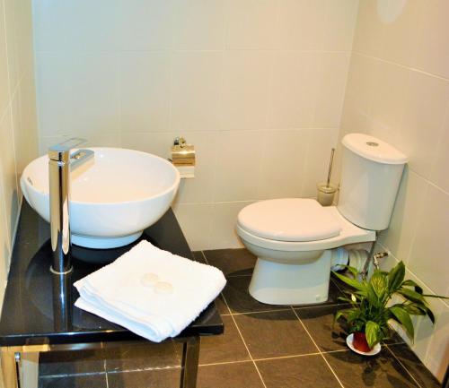 a bathroom with a white toilet and a sink at Four Saints Brig Y Don Hotel in Llandudno