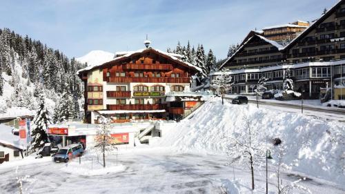 a large building in the snow in a town at Hotel Almhof in Hochfugen