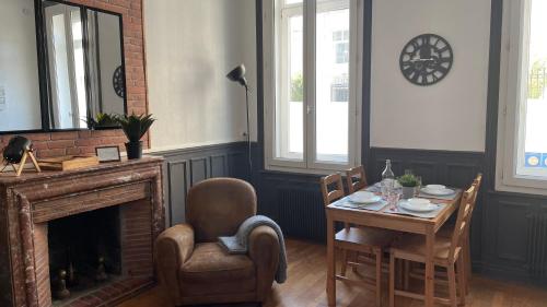 comedor con mesa y chimenea en L industriel rémois, centre ville, proche de la cathédrale, en Reims