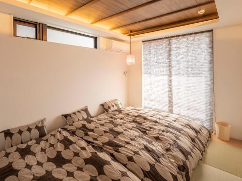 sypialnia z dużym łóżkiem i dużym oknem w obiekcie Family Inn Kei 慶 w mieście Kioto