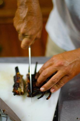 a person is preparing food on a cutting board at Desert Dew Guest House in Hutchinson
