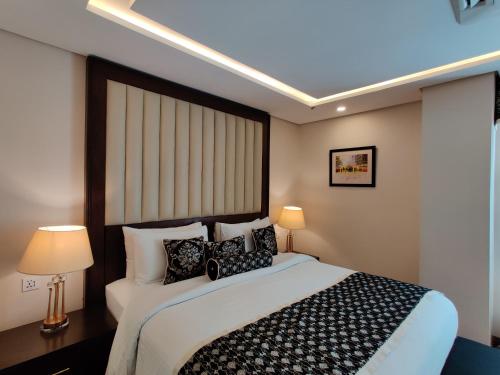 a bedroom with a large bed with black and white pillows at Ramada by Wyndham Lahore Gulberg II in Lahore