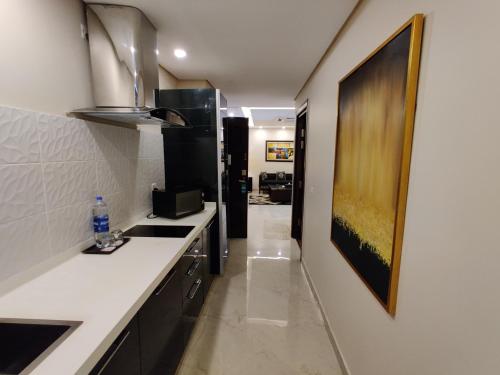 a kitchen with a white counter and a black refrigerator at Ramada by Wyndham Lahore Gulberg II in Lahore