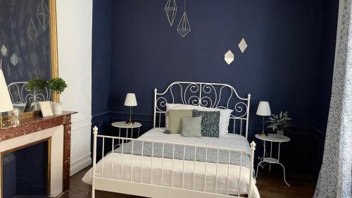 1 dormitorio azul con 1 cama y chimenea en Le classique champenois, centre ville, proche cathédrale en Reims