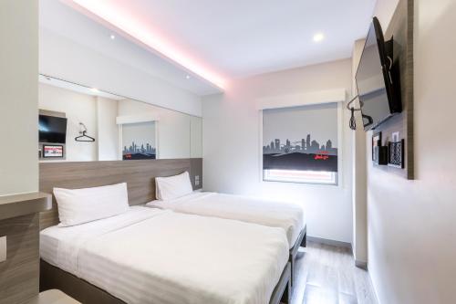 a hotel room with a bed and a television at Red Planet Bangkok Surawong in Bangkok