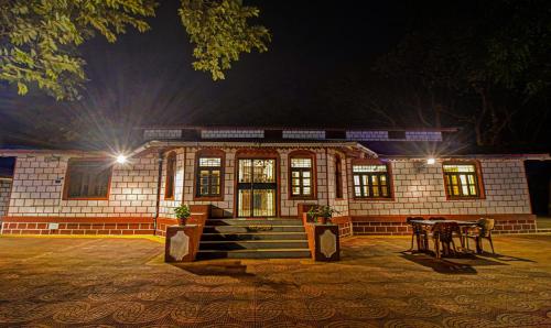 un bâtiment la nuit avec des lumières devant lui dans l'établissement Treebo Trend Shalimar In The Forest Matheran, à Matheran