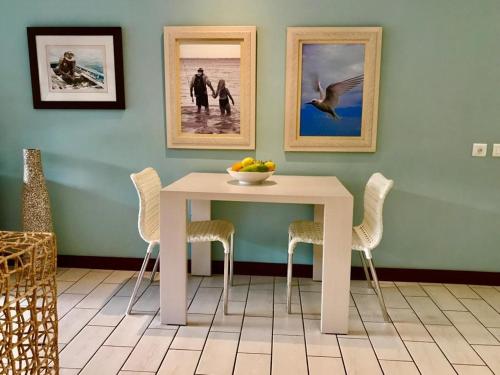 una mesa blanca con sillas y un bol de fruta en ella en Bigarade Suite by Simply-Seychelles, en Eden Island