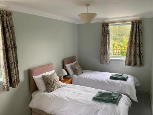 a bedroom with two beds and a window at Granite Cottage in Nethy Bridge