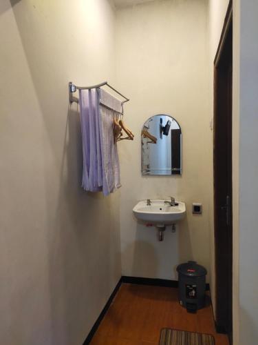 W łazience znajduje się umywalka i lustro. w obiekcie Mudhia Homestay w mieście Magelang