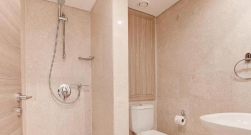 y baño con ducha, aseo y lavamanos. en Ground floor apartment with golf and sea views - Roudias, Aphrodite Hills Resort en Kouklia