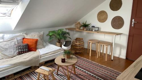 een woonkamer met een witte bank en een tafel bij Le cosy marnais, centre ville, vue cathédrale in Reims