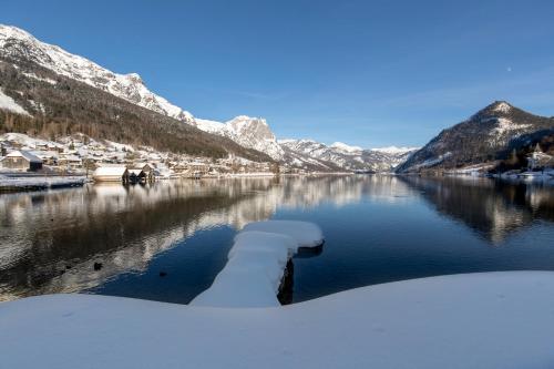 a view of a lake with snow covered mountains at Ferienwohnung Syen in Grundlsee