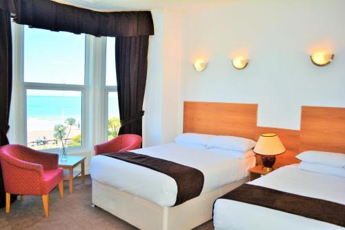 Cette chambre comprend 2 lits et une fenêtre. dans l'établissement Four Saints Brig Y Don Hotel, à Llandudno