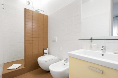 Baño blanco con lavabo y aseo en Flats4Rent Delia, en Verona