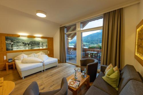 a hotel room with a bed and a large window at Hotel zum Weissensee in Weissensee