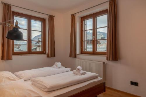 - 2 lits dans une chambre avec 2 fenêtres dans l'établissement Post Residence Apartments incl ZAK SUMMER CARD by All in One Apartments, à Zell am See