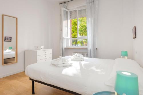 Un dormitorio blanco con una cama blanca y una ventana en Flats4Rent Delia, en Verona