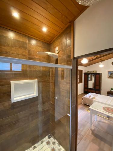 uma casa de banho com um chuveiro e uma porta de vidro em Chalé da Estância em Santa Teresa ES em alto São Lourenço Proximo ao circuito Caravaggio 5 km em Santa Teresa