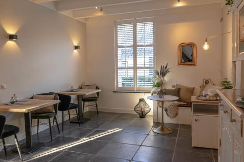 a restaurant with two tables and a window at La Vie en Roos Amerongen in Amerongen