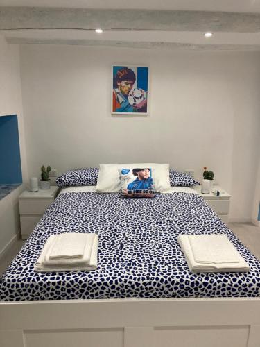 - une chambre dotée d'un grand lit avec des draps bleus et blancs dans l'établissement Casa Maradona, à Naples