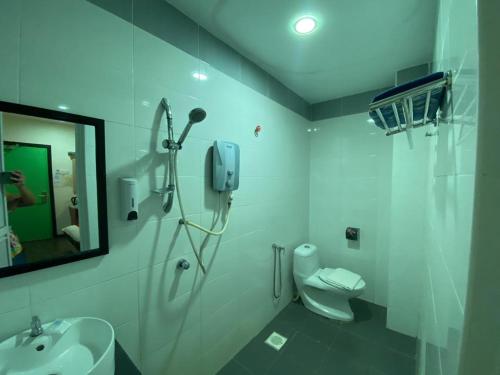 a bathroom with a toilet and a sink and a mirror at N&L HOTEL KUALA TERENGGANU in Kuala Terengganu