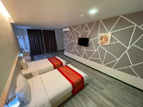 een hotelkamer met 2 bedden en een televisie bij N&L HOTEL KUALA TERENGGANU in Kuala Terengganu