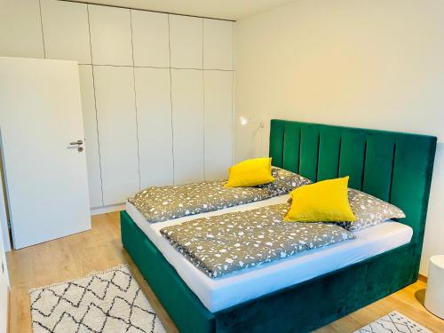 um quarto com uma cama verde e almofadas amarelas em Lermont Apartment old town em Bratislava
