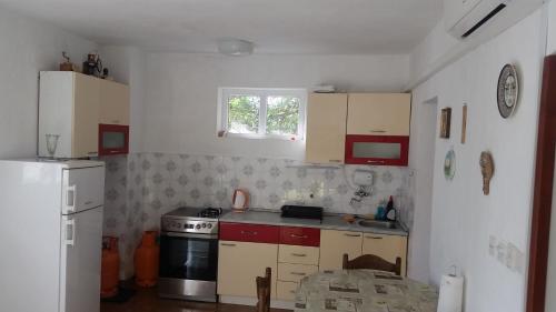 a small kitchen with a stove and a refrigerator at Spansa in Drvenik Veli
