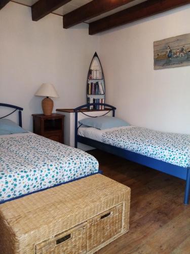 Cette chambre comprend 2 lits et un miroir. dans l'établissement GITE AVEL BREIZH, à Roz-sur-Couesnon