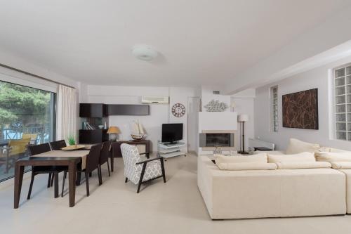 a living room with a white couch and a dining room at Punda 4 Seasons in Diakopto