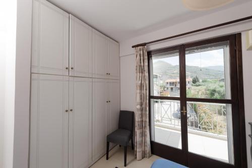 a room with a chair and a large window at Punda 4 Seasons in Diakopto