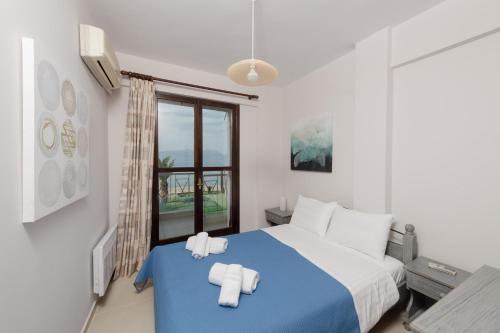 a bedroom with a blue bed with towels on it at Punda 4 Seasons in Diakopto