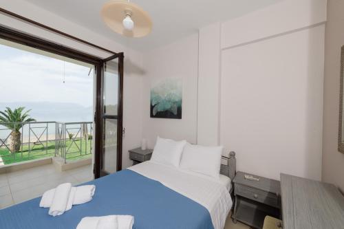 a bedroom with a blue and white bed and a window at Punda 4 Seasons in Diakopto