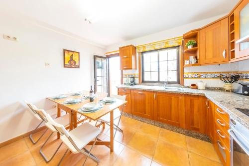 una cucina con mobili in legno, tavolo e sedie di MEDANO4YOU Las 3 Fridas a El Médano