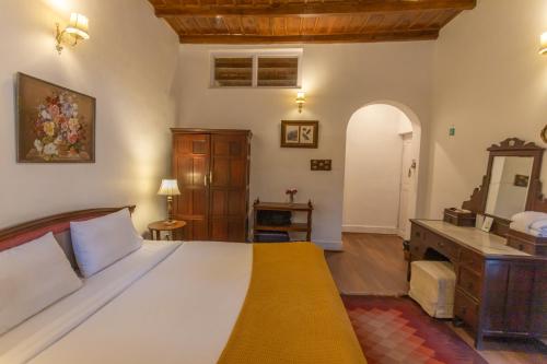a bedroom with a bed and a dresser and a mirror at Seclude Ramgarh Taradale in Rāmgarh