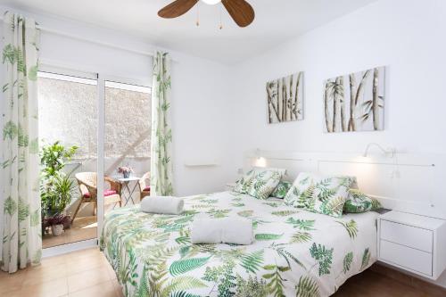 a bedroom with a bed with a green and white comforter at Gigantes Cliff Holiday Home by Sydney Playa Sur in Acantilado de los Gigantes