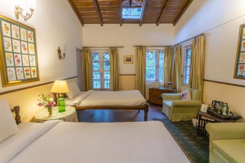 a bedroom with two beds and a living room at Seclude Ramgarh Taradale in Rāmgarh