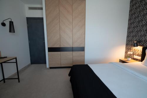 a bedroom with a bed and a closet and a desk at Vitosha Park Hotel - Free Indoor Pool & Parking in Sofia