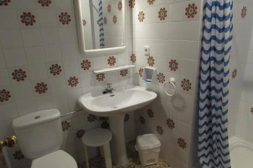 ein Badezimmer mit einem Waschbecken, einem WC und einem Spiegel in der Unterkunft Villa Pico in Sella