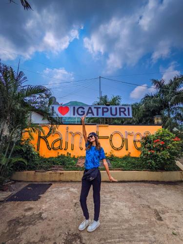 a woman is standing in front of a sign at Rainforest Resort and Spa, Igatpuri -Nature's Luxury Awaits in Igatpuri
