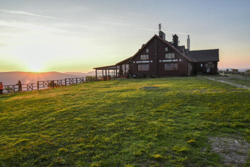 a house on a hill with the sunset in the background at Zahar Berkut in Slavske