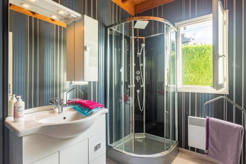 een badkamer met een glazen douche en een wastafel bij Le Chalet à la Mer in Erdeven