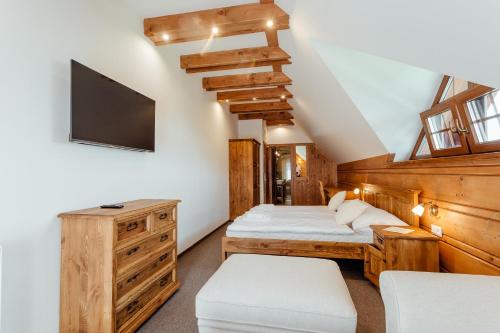 a bedroom with a bed and a tv on the wall at Wellness penzión Kráľov dvor in Čremošné