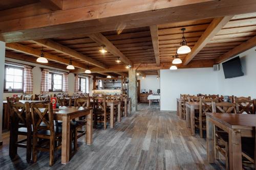 a dining room with wooden tables and chairs at Wellness penzión Kráľov dvor in Čremošné