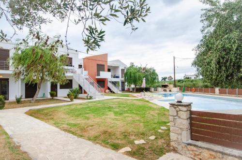 una imagen del patio trasero de una casa con piscina en The Olive Garden-Almyrida, en Almyrida