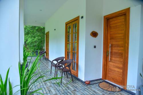 a porch with chairs and a wooden door at Simoya Nature Park in Dambulla