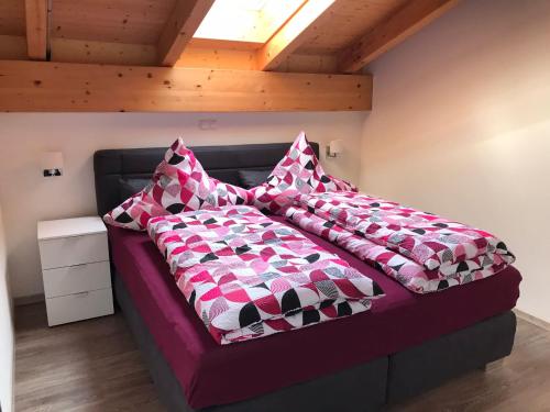 a bed with pillows on it in a room at Ferienwohnung am Freibad in Schwarzach