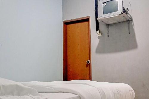 a room with a door and a tv on a wall at Arjuna 2 Homestay Syariah Dieng in Dieng